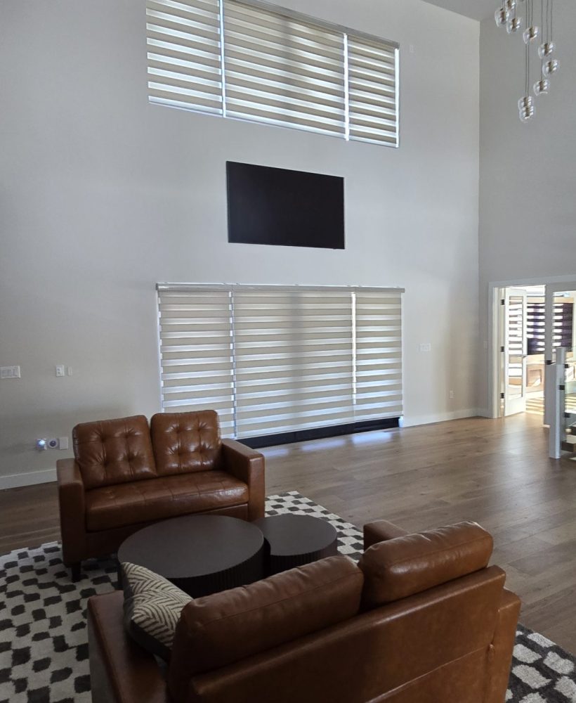 Two-story space with tall windows and horizontal blinds